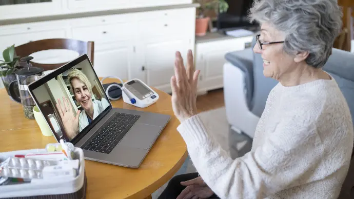An elderly woman talks to her doctor on a video call.